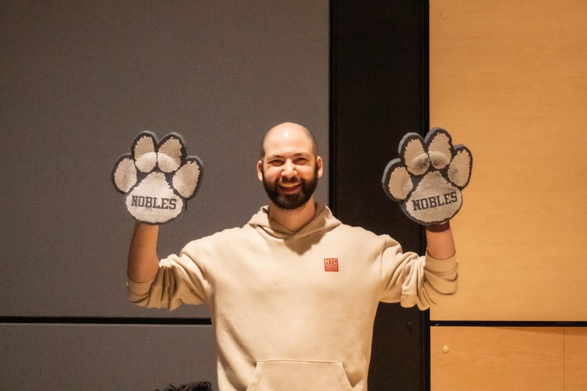 Zack Georgian, Assistant Technical Director of the Performing Arts Department, wearing his signature Nobles Friday paws in Lawrence Auditorium.